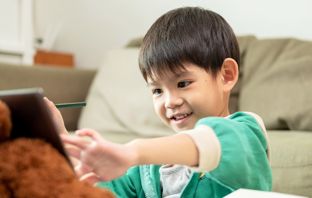 正在使用平板學習的男孩與女孩，以及在一旁守候的成人女性