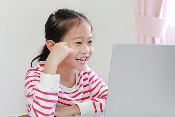 看著電腦螢幕做出勝利手勢的女孩