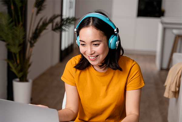 戴著耳機、笑著參加線上課程的女性