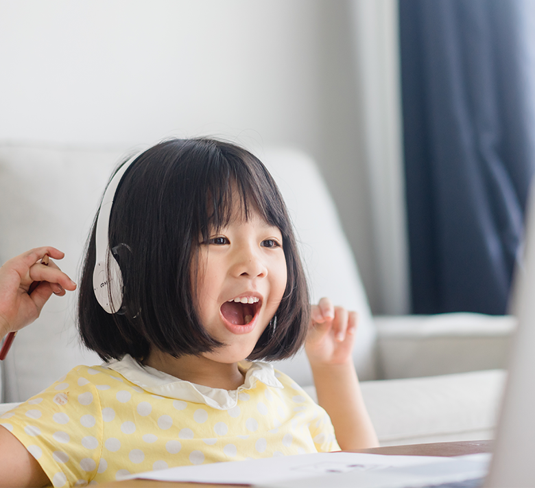 透過筆電學習、露出燦爛笑容的男孩