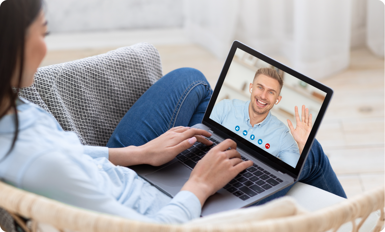 Mulher fazendo uma chamada de vídeo em um laptop em um sofá