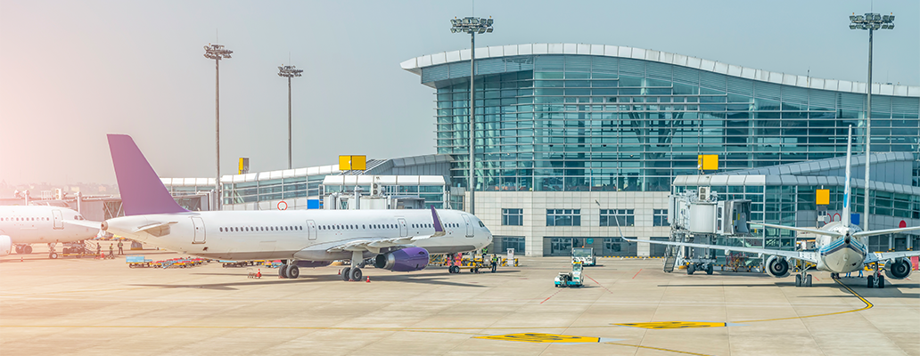 空港の滑走路に並ぶ飛行機とターミナルビル