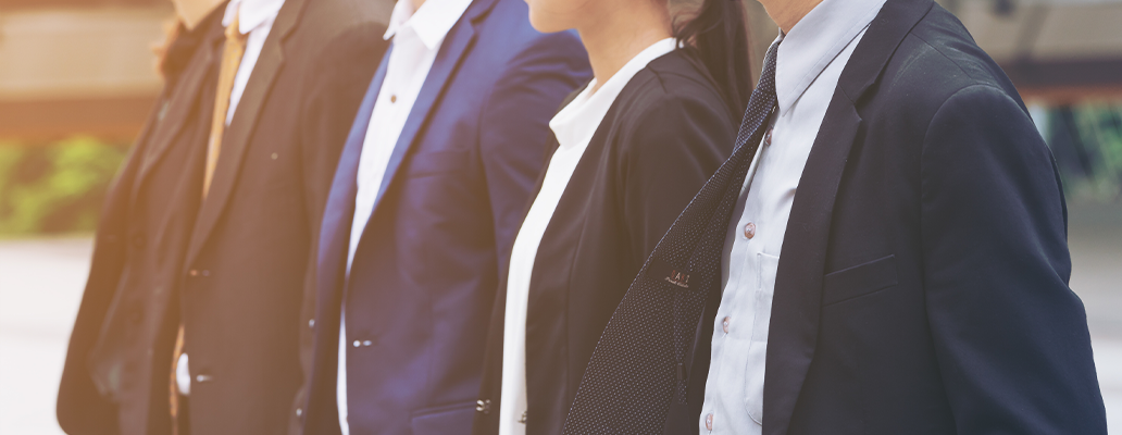 スーツ姿の男女が並んで立つ様子