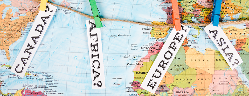 世界地図にカナダ・アフリカ・ヨーロッパ・アジアと書かれた札が並ぶ