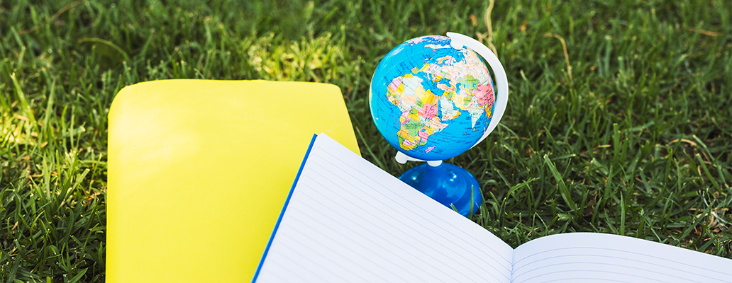 芝生の上に置かれたノートと地球儀