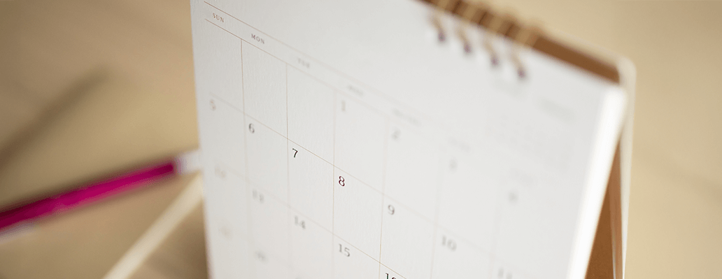 卓上に置かれたカレンダーとペン