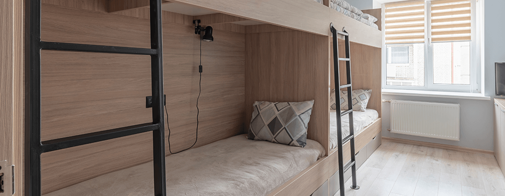 木製の二段ベッドが並ぶ明るい部屋