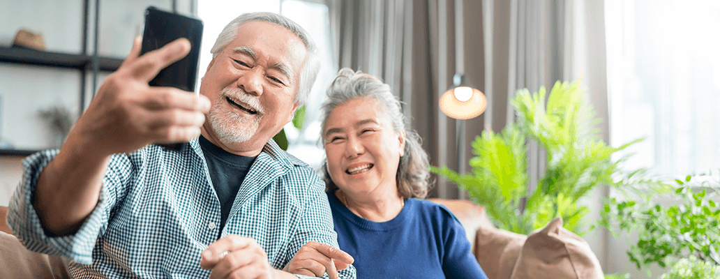 スマートフォンで笑顔のセルフィーを撮るシニア夫婦