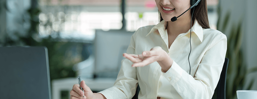 オフィスでヘッドセットをつけて対応する女性