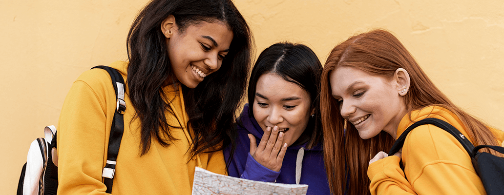 地図を見ながら笑顔で話す3人の学生