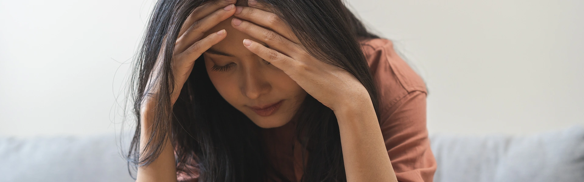 留学に不安を感じて頭を抱える女性のイメージ