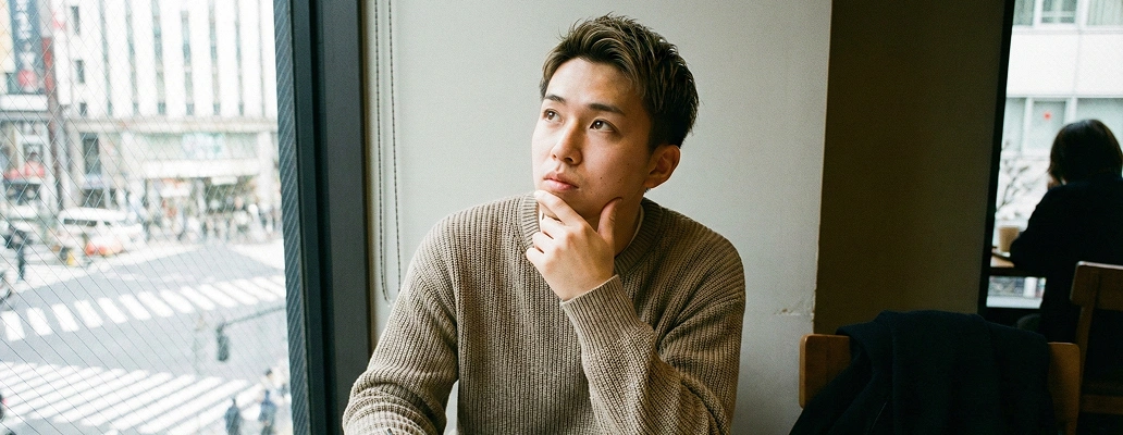 カフェで将来について考える留学生の女性