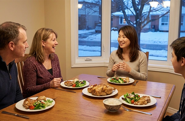 カナダのホームステイ先でホストファミリーと食事をする留学生