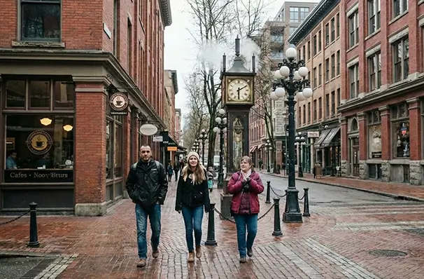 バンクーバー・ガスタウンの蒸気時計と歴史ある街並みを歩く観光客