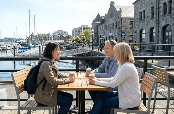 ビクトリアの港沿いカフェで英語で会話を楽しむ人々