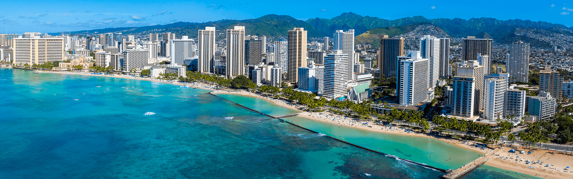 ハワイの海と街並みを望む留学先の風景 | ワイキキビーチとホノルルの高層ホテル群のパノラマ風景