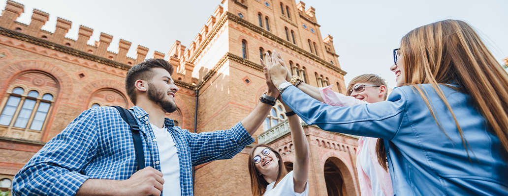 アイルランド留学のメリットを象徴するヨーロッパの歴史的建物の前で交流する学生たち