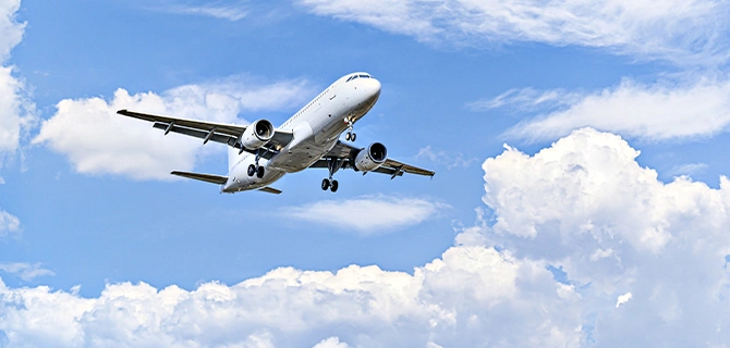 青空の下を飛行する旅客機の様子