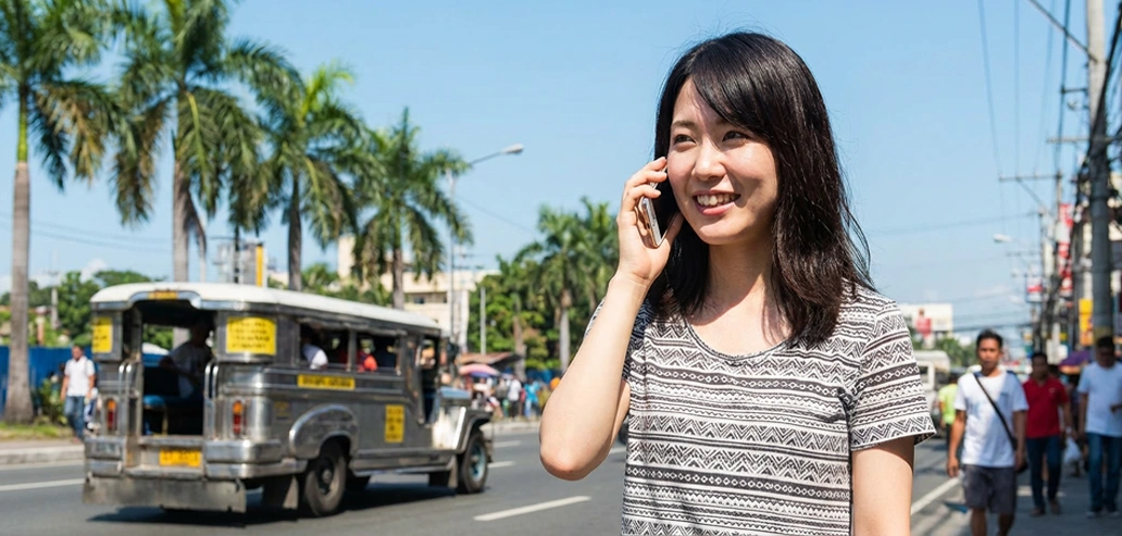 街中でスマートフォンを手にする女性の様子