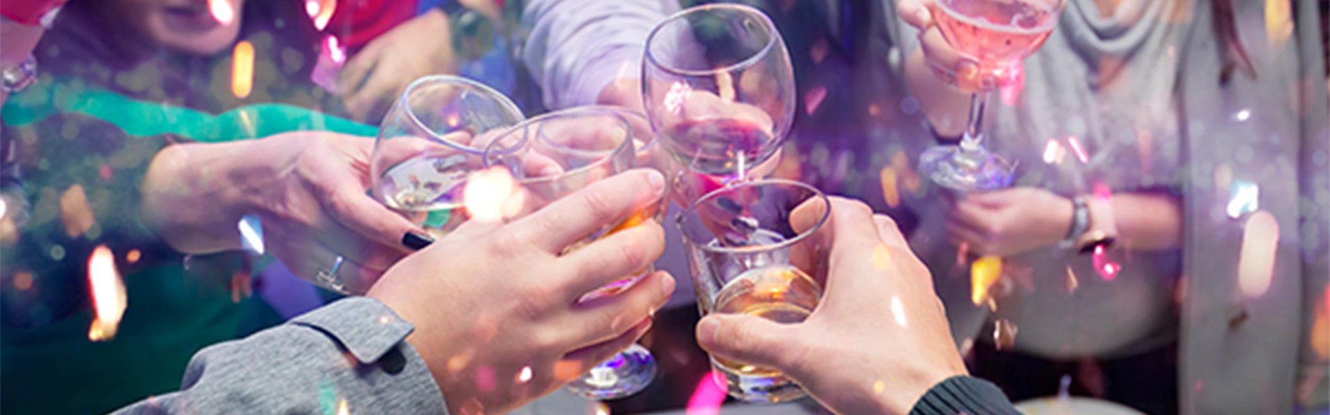 夜のイベントで乾杯をする人々の手元