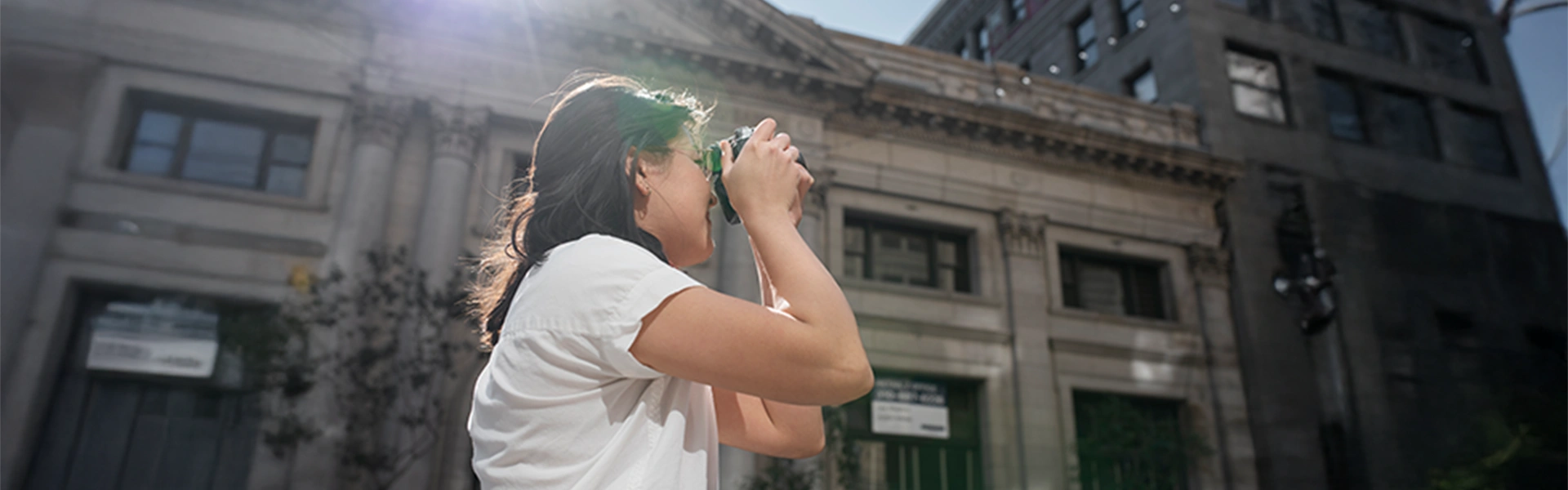 歴史的建造物を背景に写真撮影を楽しむ女性