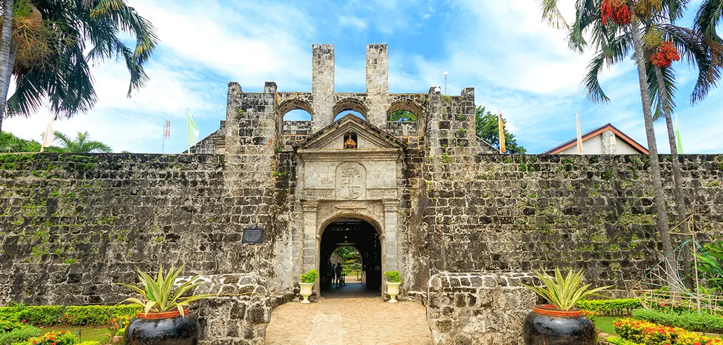 南国の木々に囲まれた歴史ある城門の外観