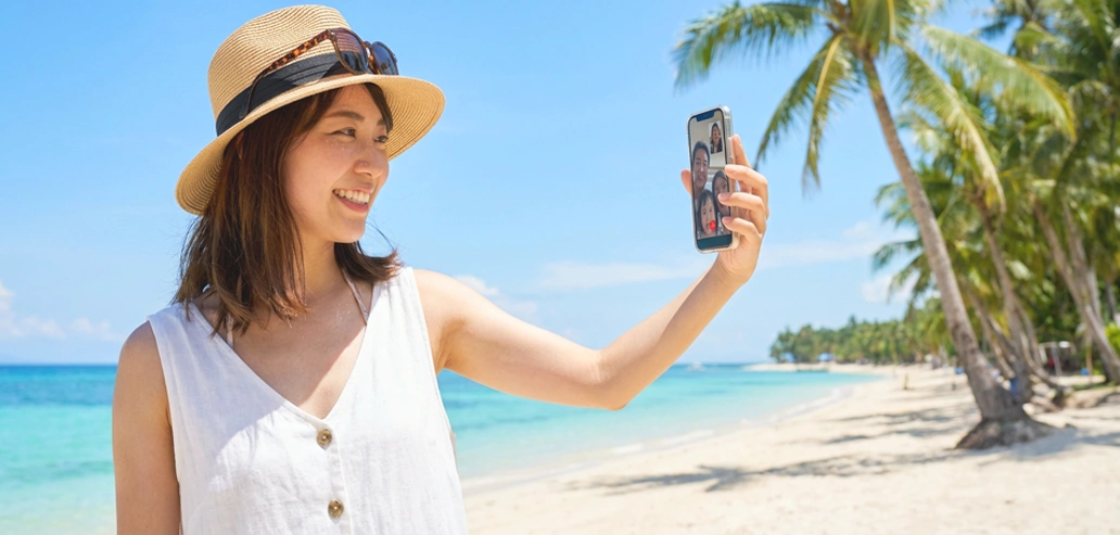 フィリピンのビーチでスマートフォンを使う留学生のイメージ