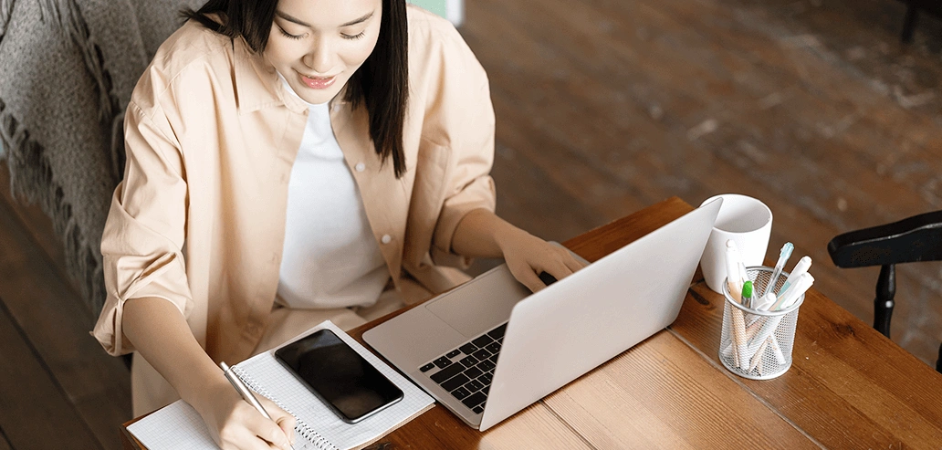 留学の目的や目標を整理しながらノートパソコンで作業する女性