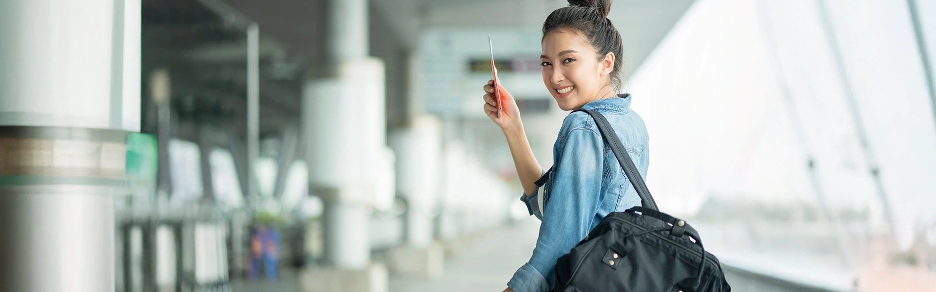 空港で出発を控え、振り返って微笑む旅行者