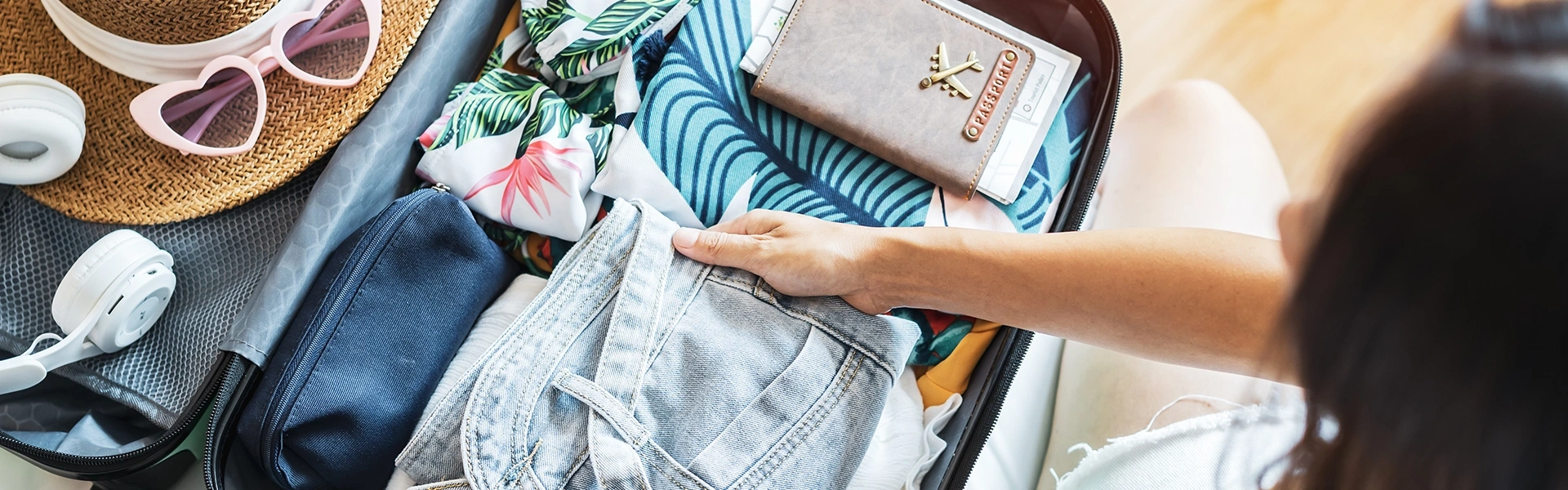 旅行の準備でスーツケースに衣類や小物を詰めている様子