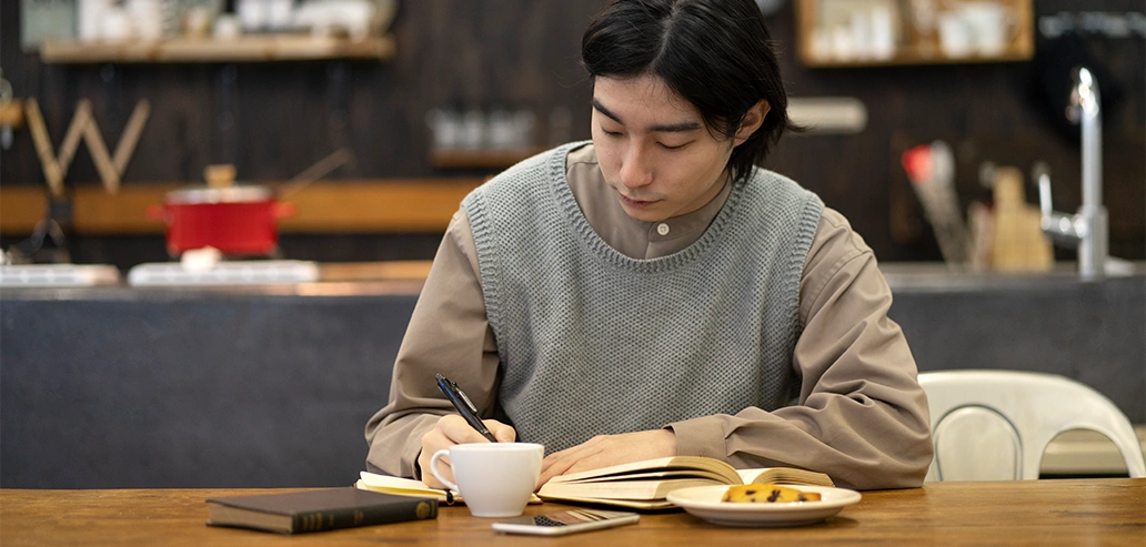カフェでリラックスしながら勉強する男性