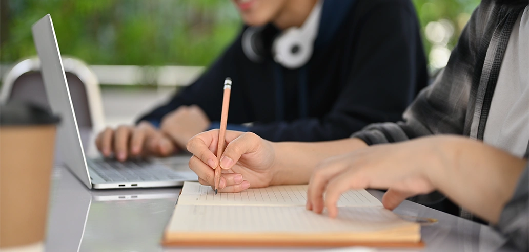 友人と一緒にノートを使って勉強する様子