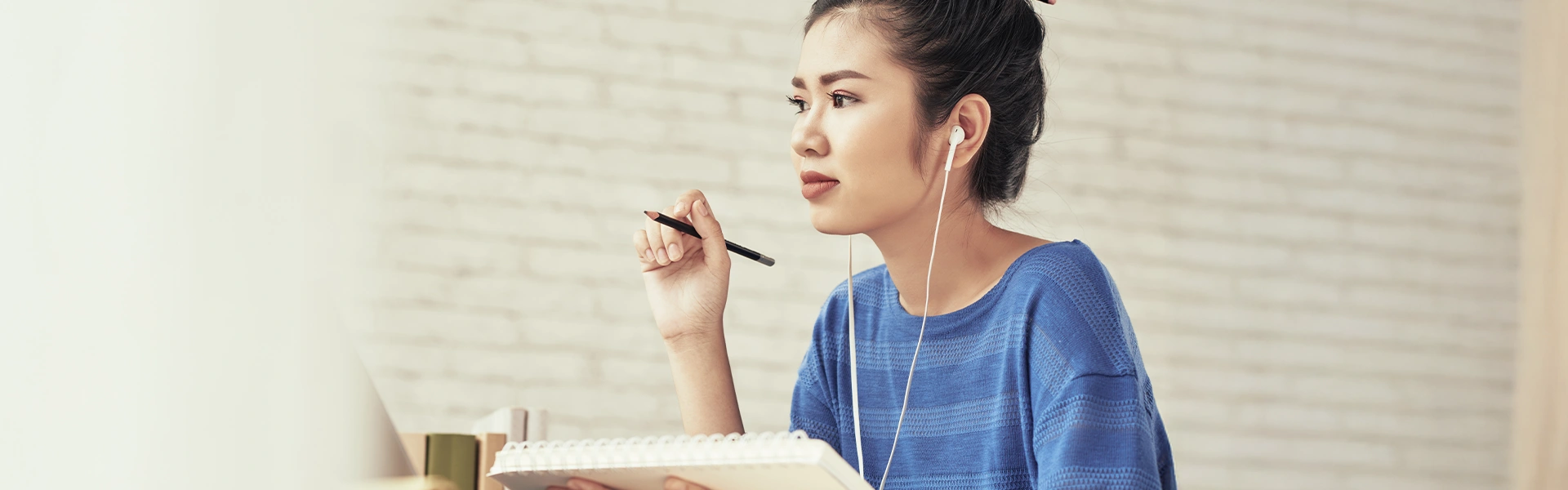 イヤホンをつけて学習について考える女性
