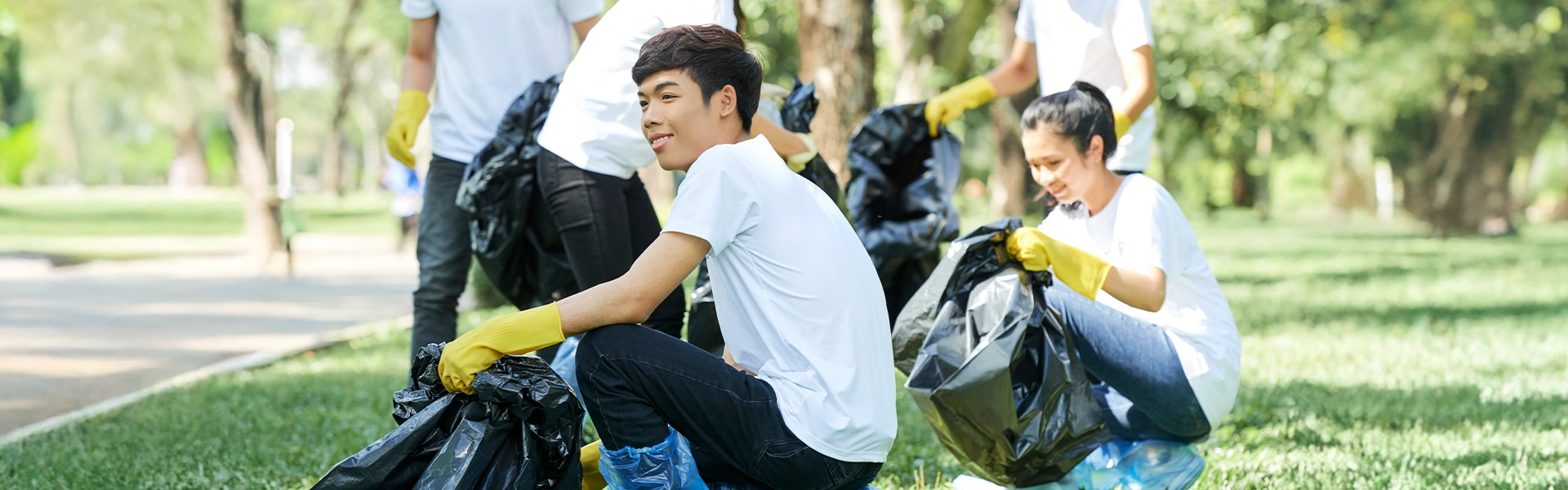 屋外でボランティア活動に参加する留学生
