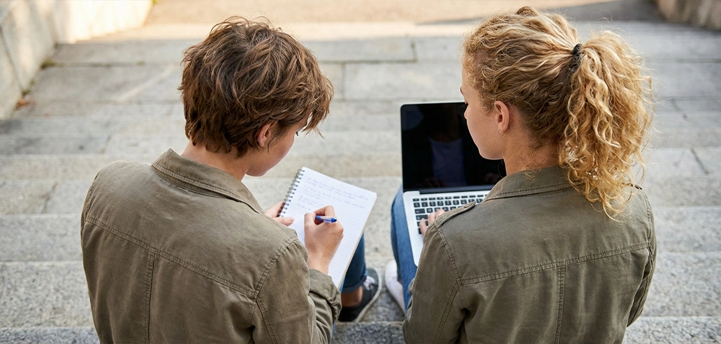 ノートパソコンを見ながら授業内容を確認する学生