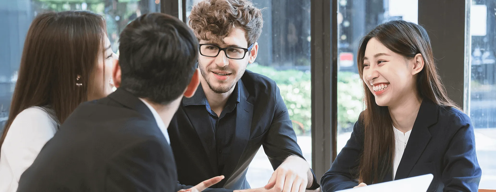 海外ビジネス環境で英語を使って話し合う男女の写真