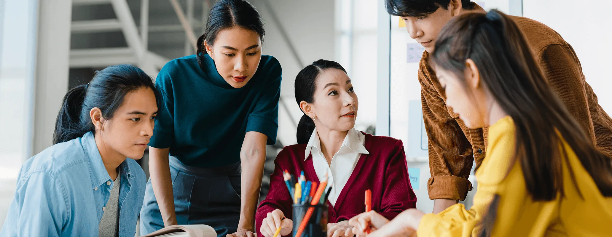 IELTSスコアアップを目指し、教材を囲んでグループ学習をする学生たち