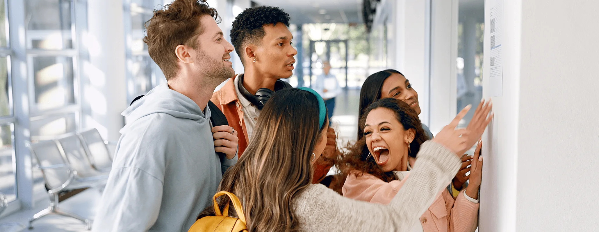 海外学校の掲示板を見て喜ぶ学生たちのグループ