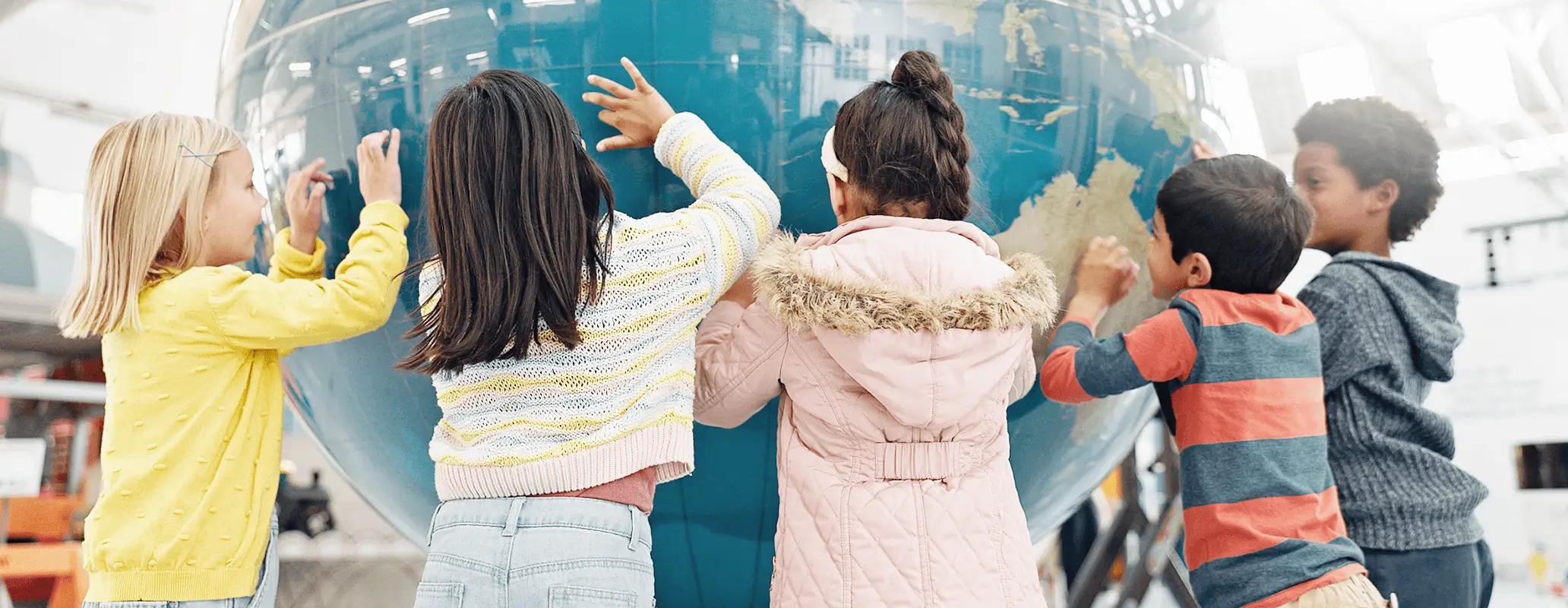 大きな地球儀に触れて学ぶ子どもたち