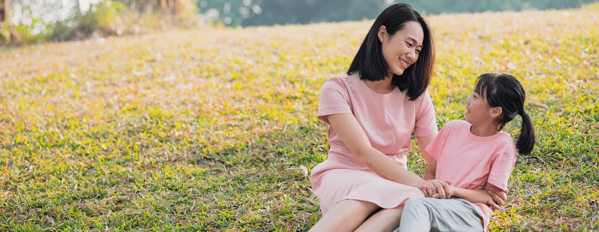 芝生の上でリラックスしながら親子の時間を楽しむ母娘の様子