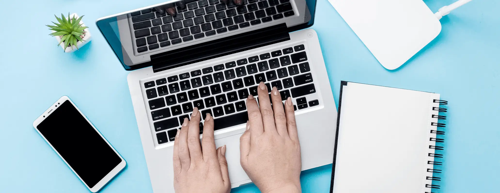 ノートパソコンで作業中の手元の様子とワーケーションの業務環境イメージ