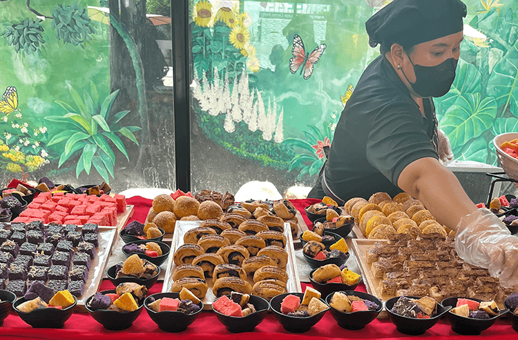 マスクをした人がカラフルなデザートやお菓子を屋外で販売している