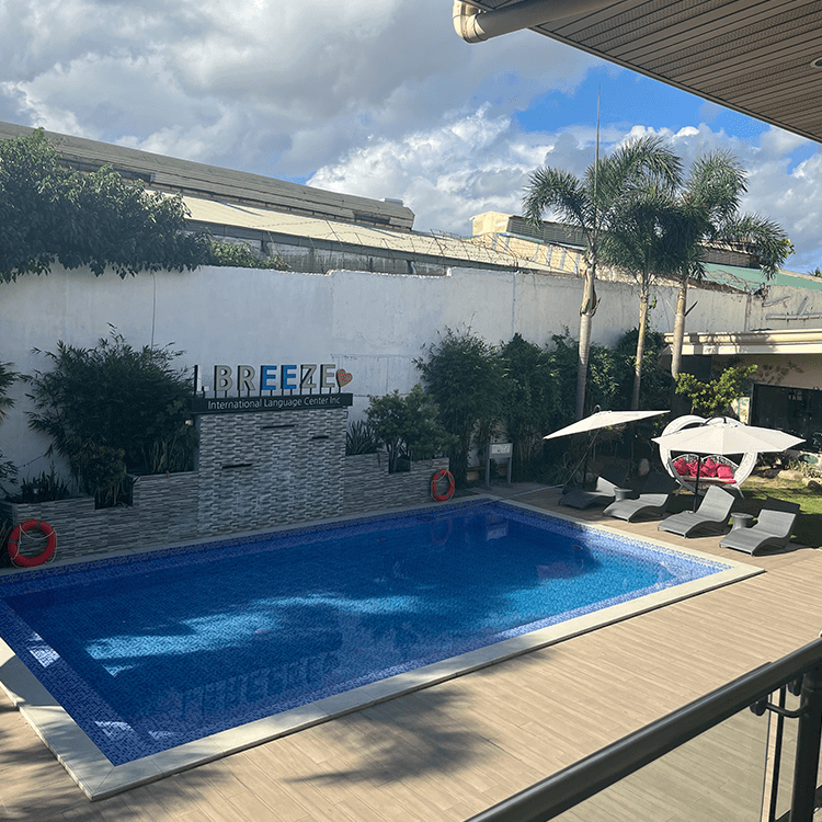 プールサイドにパラソルと椅子がある屋外施設の景色