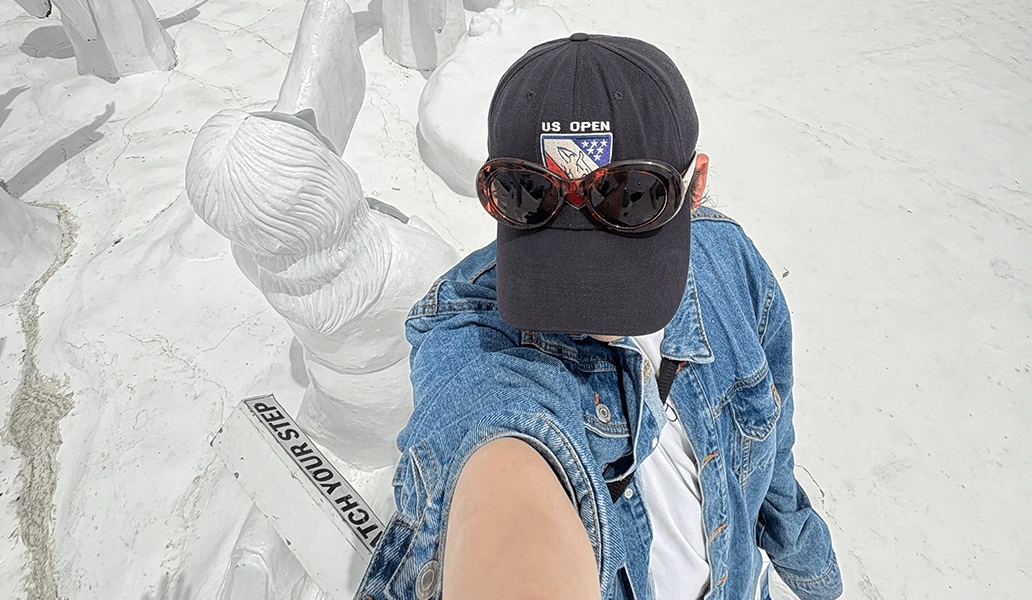 教室で笑顔の学生二人がピースサインをしながらホワイトボードの前でポーズを取っている