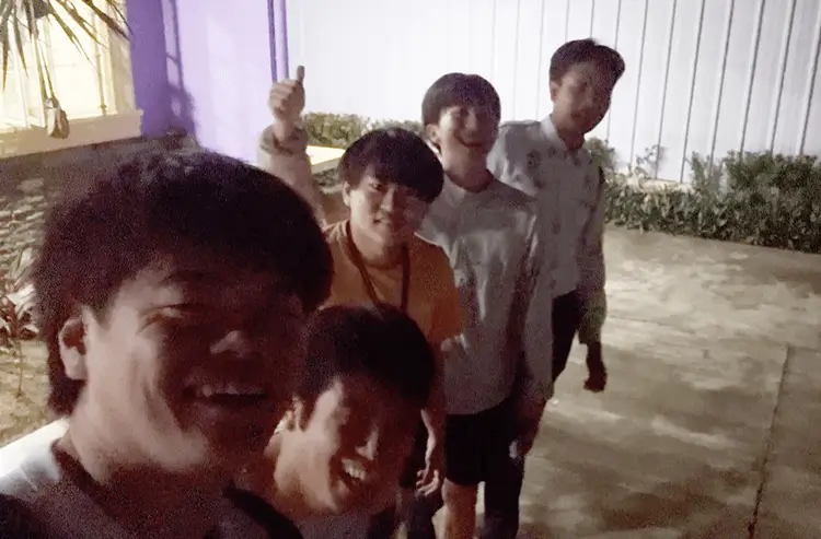 夜の屋外で笑顔で集まる留学生グループ