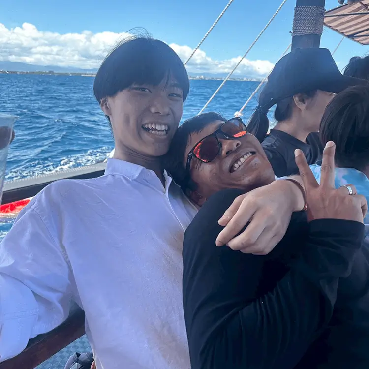 海上のボートでピースサインをする男性たち