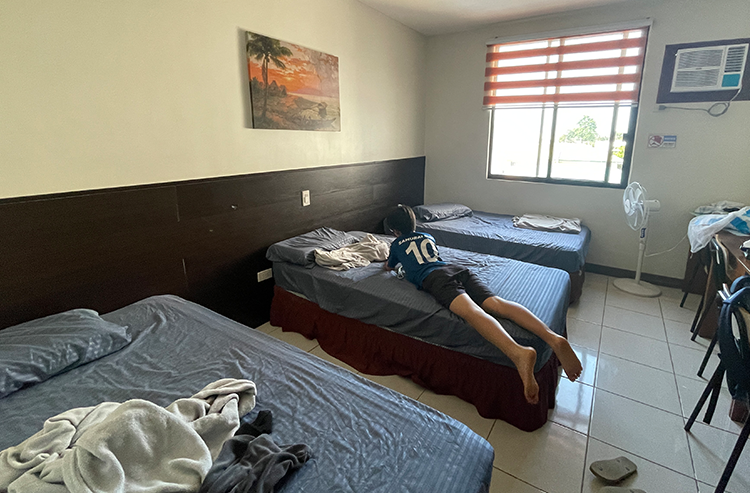 複数のベッドがある屋内の宿泊施設で人物が横になっている