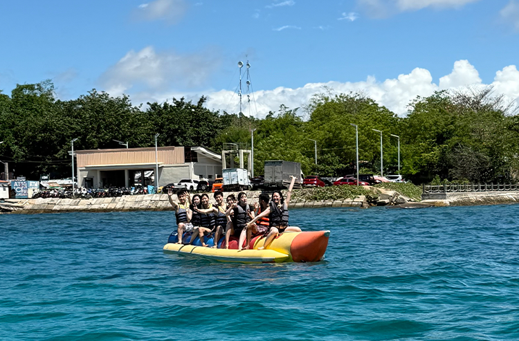 黄色いバナナボートに乗る人々のグループ、海上でのウォータースポーツ