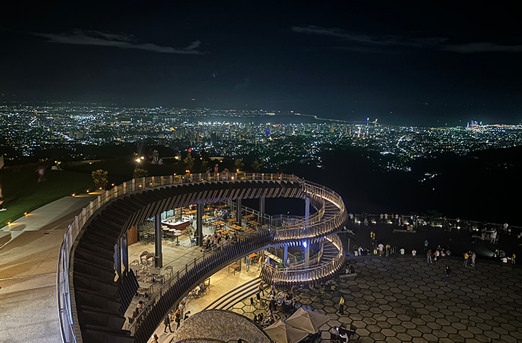 夜景を見下ろす螺旋状の展望デッキ、街の明かりが広がる景色