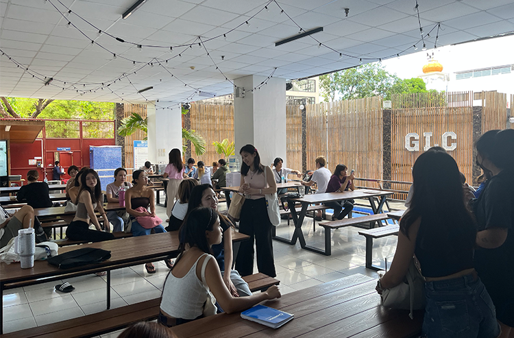 オープンなラウンジエリアで学生たちがくつろぎながら会話している様子